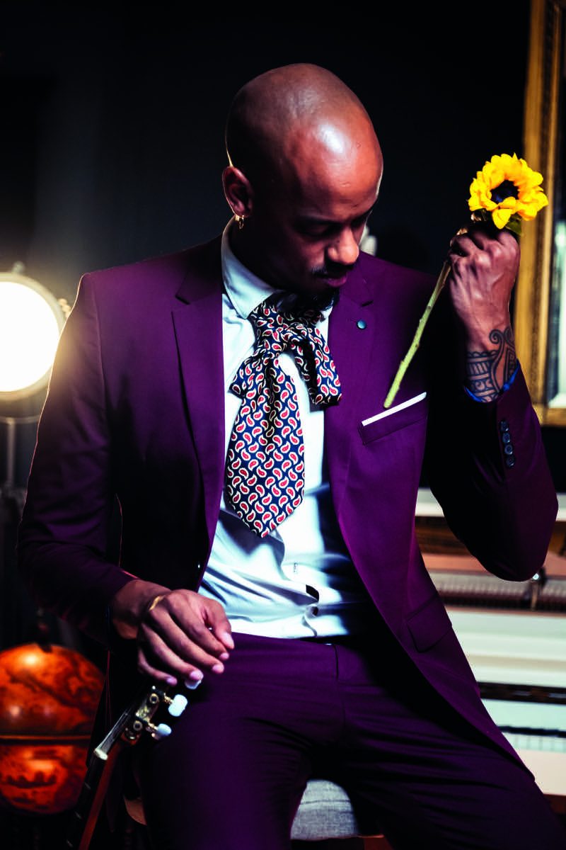Muzanzo tenant une fleur de tournesol lors de la première Artēfact Session